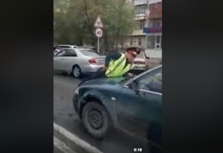Шымкенттік полицей жол ережесін бұзған көліктің үстіне жатып алды (видео)